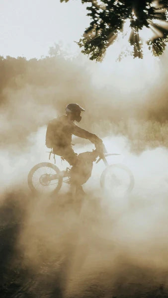 electric dirt bike rider kicks up dust on a trail, highlighting off-road action