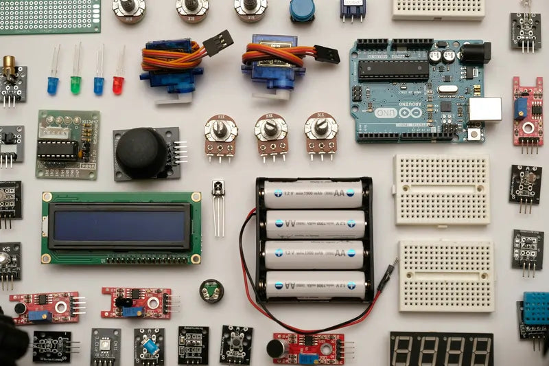 Flat lay of electronics with cells, display, sensors, and microcontroller boards for DIY e-bike projects