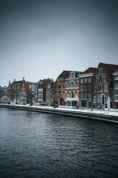 Historic Dutch buildings along a canal in the Netherlands, a typical scene where securely parking your e-bike is crucial for insurance purposes.